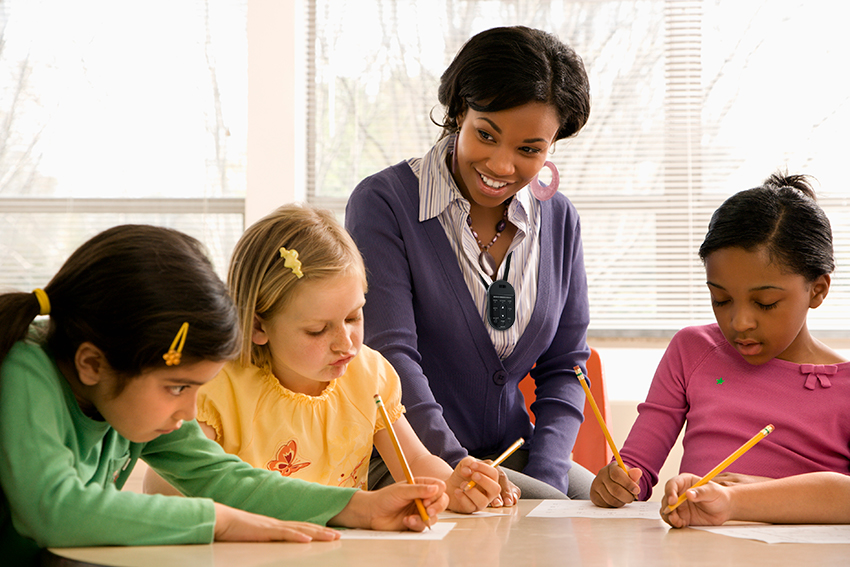XD Teacher Mic with Small Group Teacher wearing an XD Teacher Mic working with a small group of students
